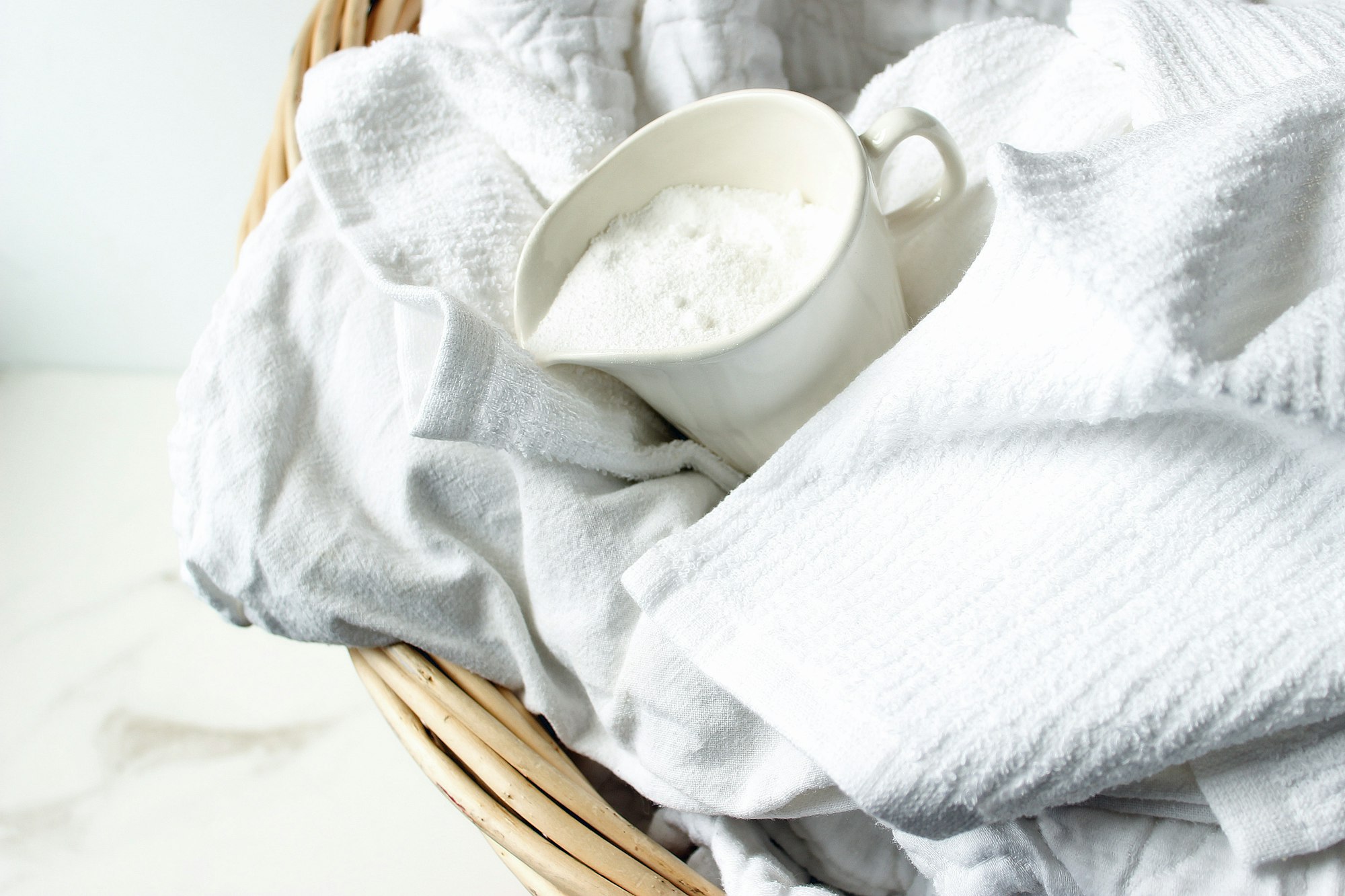 Laundry basket with laundry and cup of powder